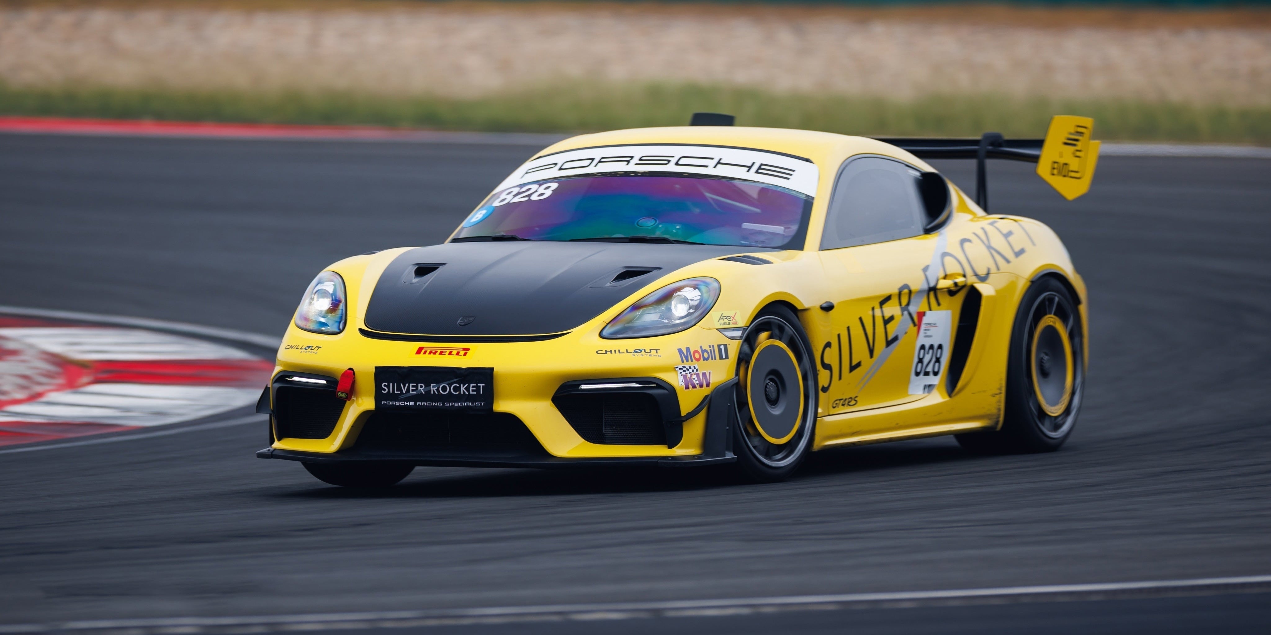 Yellow Porsche race car on a track with 'Silver Rocket' branding.